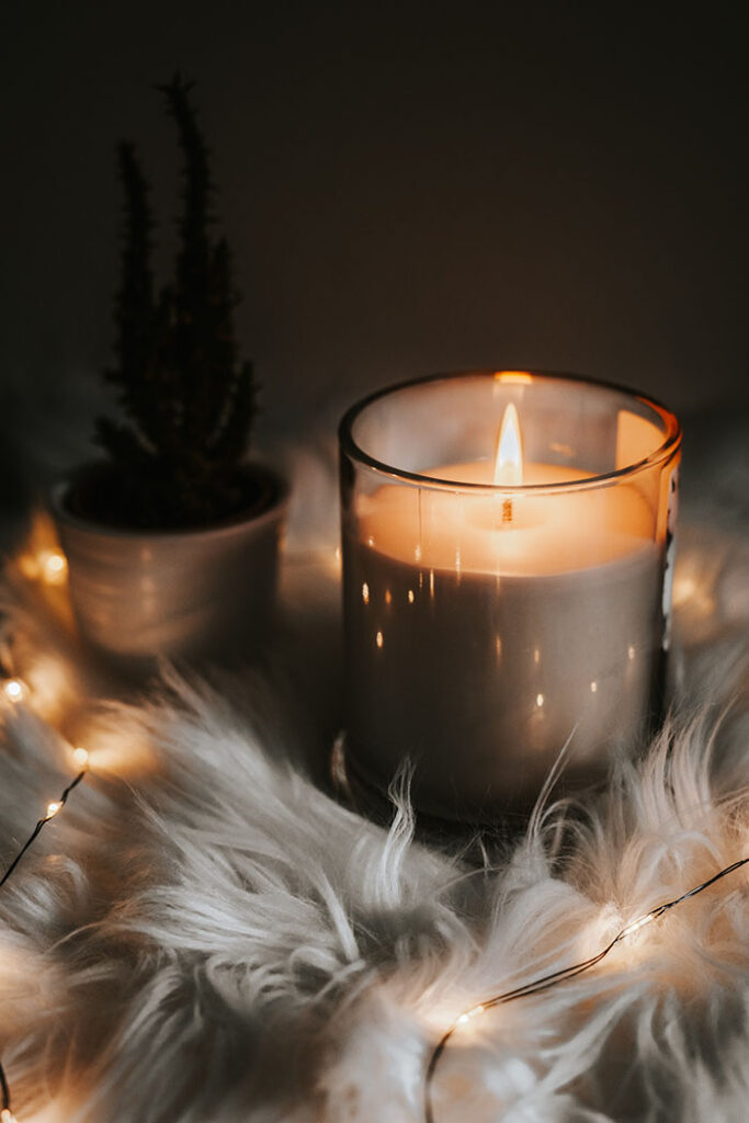 candle and fairy lights on white fur rug