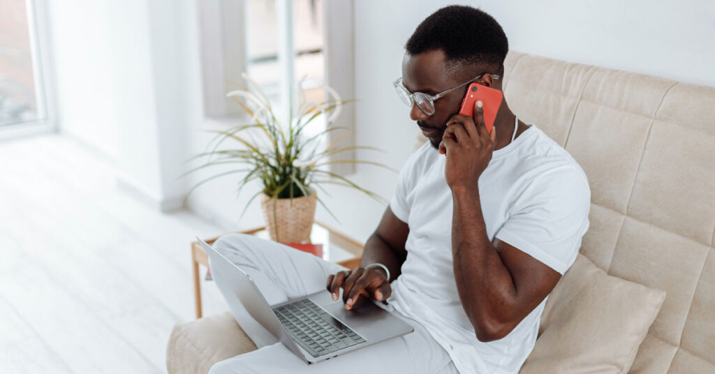 Man working on laptop on phone virtual assistant