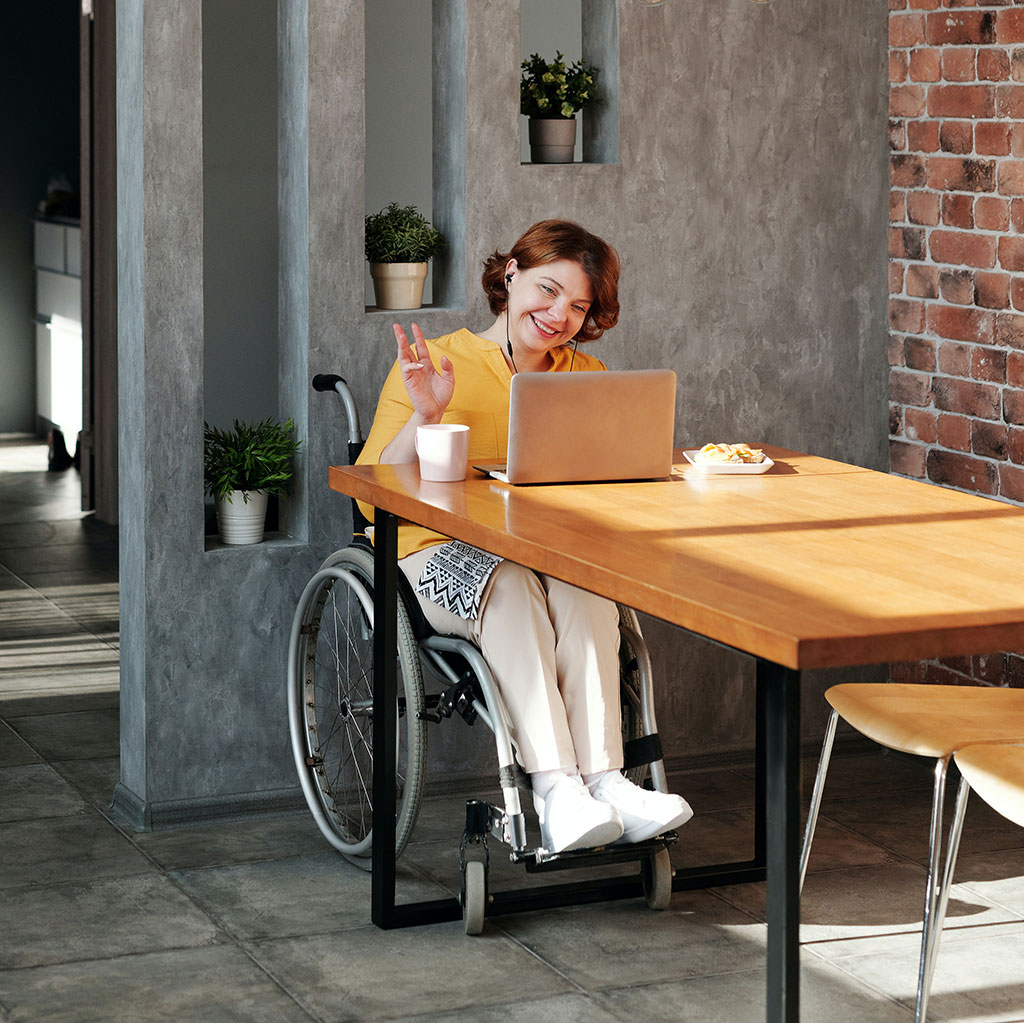 Disabled woman in wheelchair working on a laptop as a virtual assistant